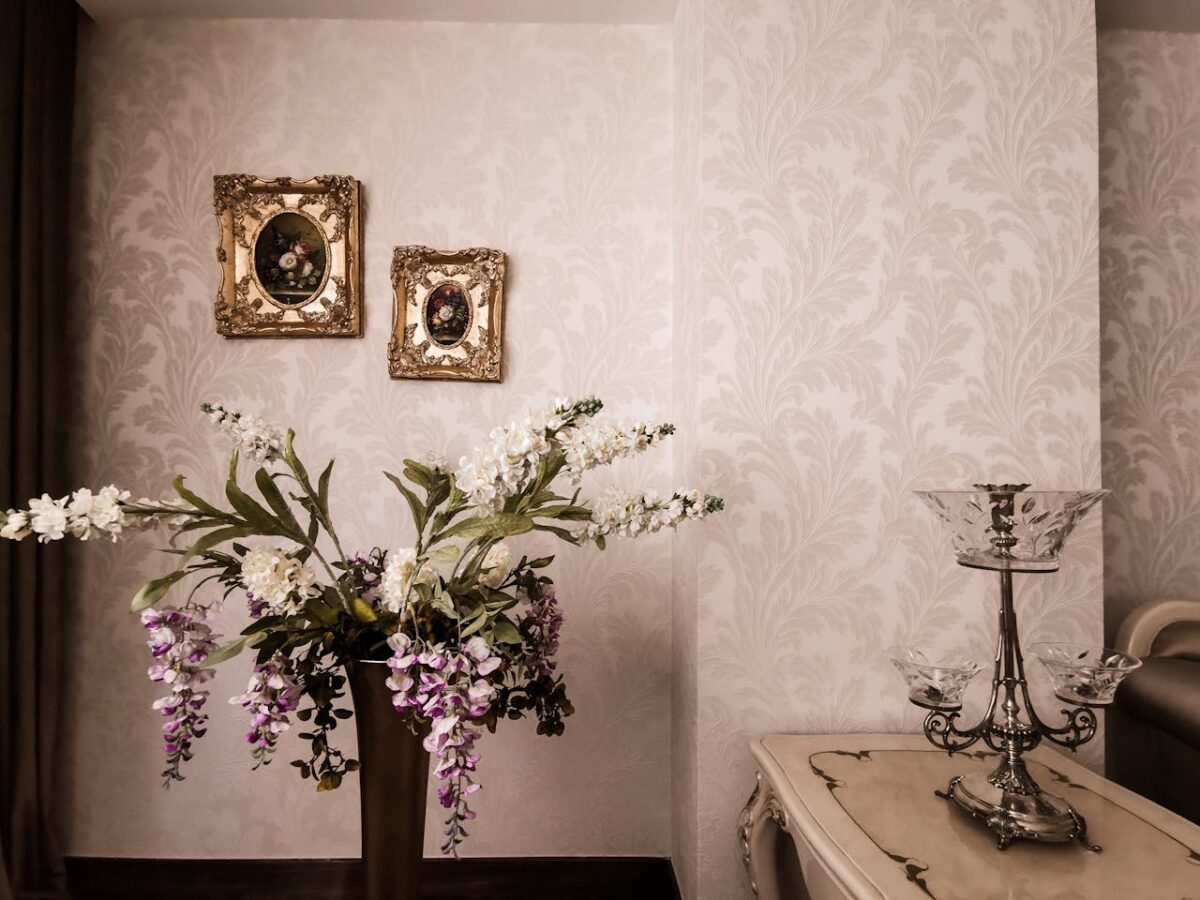 A sophisticated interior with a floral arrangement, ornate frames, and vintage decor.