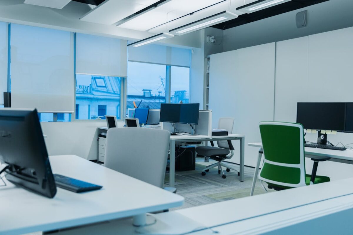 our-story Bright and modern office environment with computer workstations and large windows.